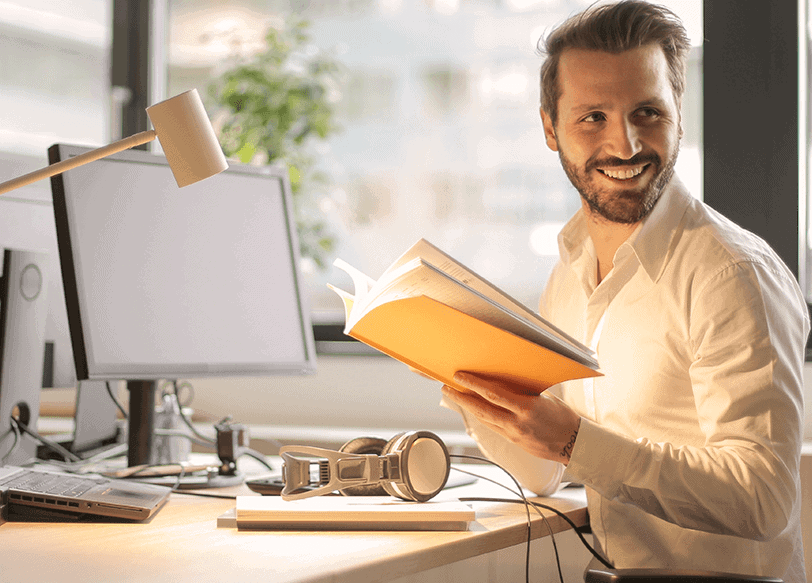 Mann mit Buch in der Hand im Büro