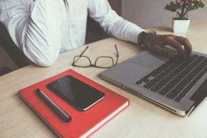 Laptop und Notitzbuch auf einem Tisch-buchhaltungssoftware online